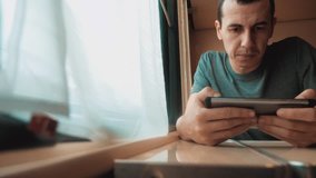 man travel writes smartphone a message social media in the messenger sits on the train by the window traveler concept train railroad journey travel. slow motion video. beautiful from window of moving