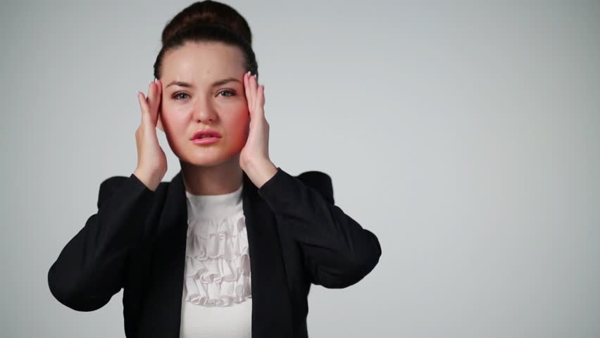 Woman in suit touches forehead and temporal fossa during headache
