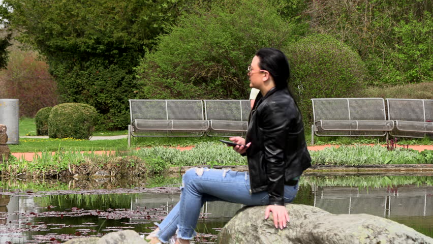 Brunette near the lake with a phone