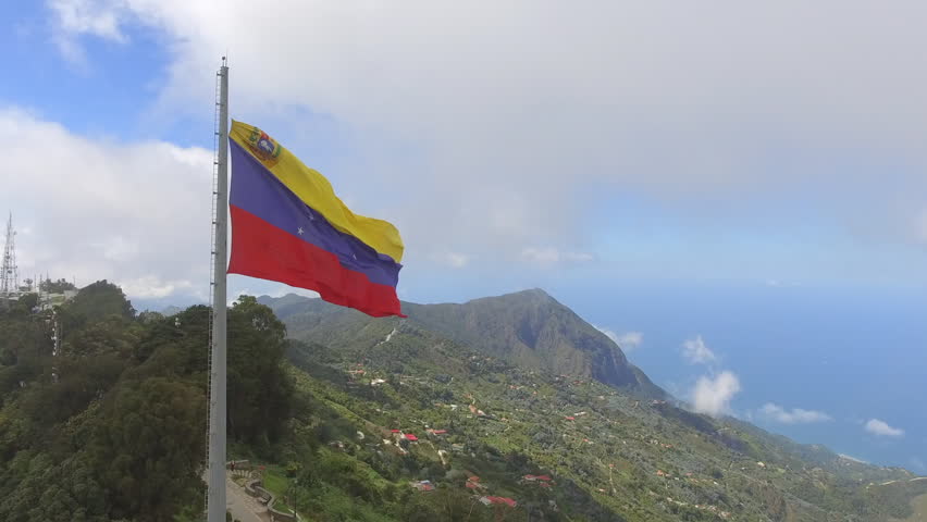 Charming aerial view of an immense Venezuelan flag on the top of El Avila hill. Epic look of the landscape and the symbol of the Venezuelan nation. Caracas Venezuela Royalty-Free Stock Footage #1028406893
