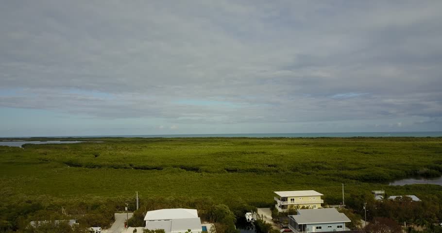 AERIAL: lifting up over the unique terrain of Key Largo, Florida on a very cloudy day.