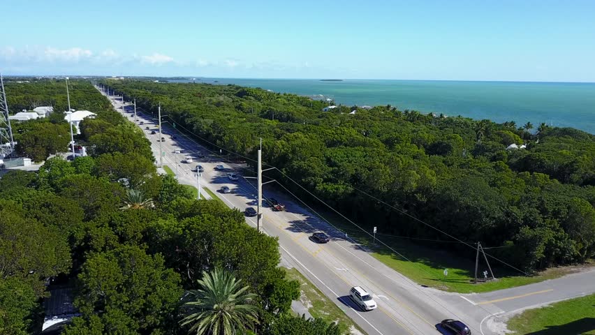 AERIAL: angled still shot looking at the busy main highway that cuts straight through Key Largo, Florida.