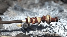 Hommade picnic shashlik (onion, sausage, bacon) grilling on campfire.  in the forest 4K stock video.