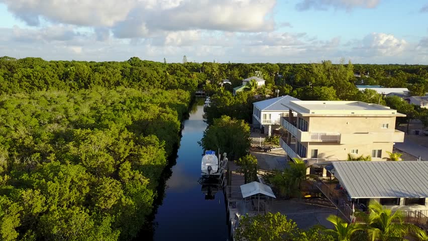AERIAL: symmetrical still shot sitting over a canal surrounded by housing in Key Largo, Florida.