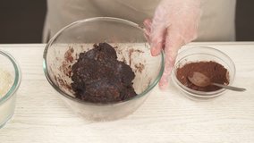 Homemade candies making concept. Recipe demonstration video. Woman adding almond meal to the mixture of ground nuts and dried exotic fruits