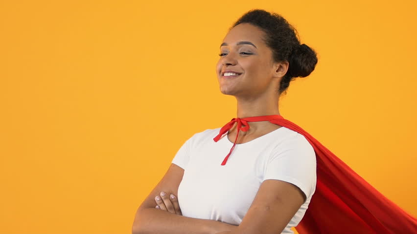Self-confident afro-american woman with crossed hands in red cape, super hero | Shutterstock HD Video #1028434412