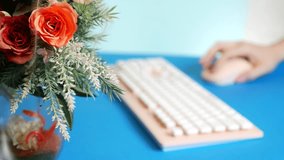close-up. stylish greeting video card. female hands are typing on a pink keyboard, next to a flower. 