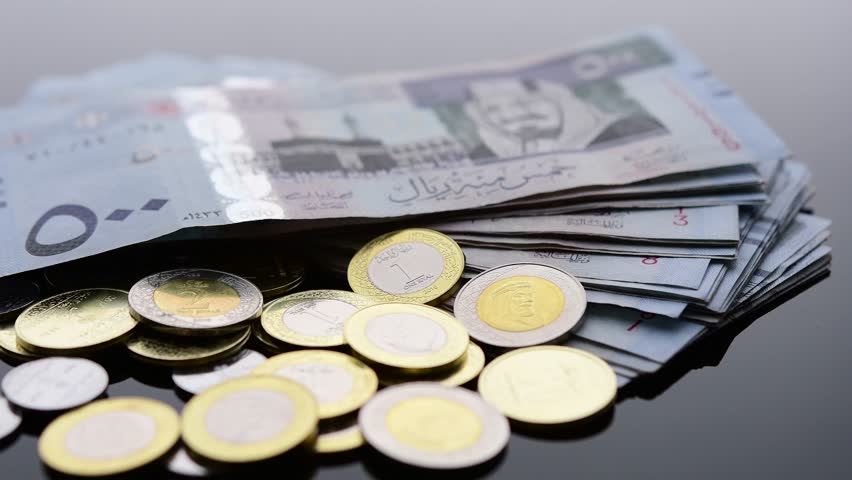 Stack of Saudi Arabia currency, Saudi Riyal paper of five hundreds riyals and Saudi  Riyal coins rotate on soft background.