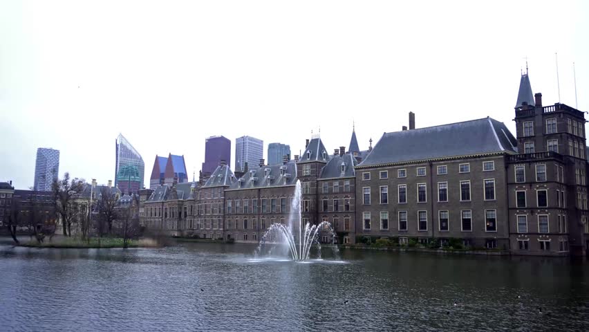 View of the Binnenhof House of Parliament and the Hofvijver lake with skyscrapers in the background. The Hague, Netherlands