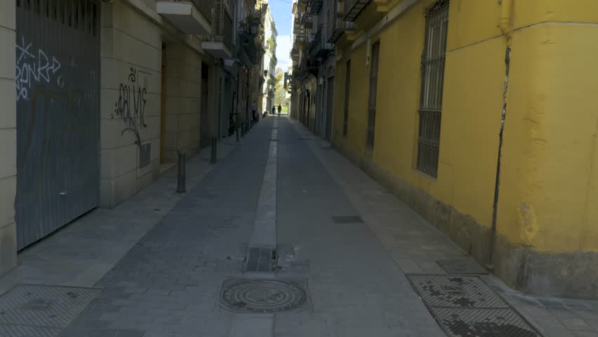 Shot down a narrow street between two buildings, and then the camera tilts up to the tops of the buildings.