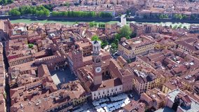 Aerial drone video of iconic Erbe square or piazza Erbe featuring Lamberti Tower in the heart of Verona, Veneto, Italy