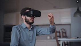 Fun man is playing by modern virtual reality computer technology glasses. Digital future equipment for gaming and working at home apartment. Excited video game and casual relax concept with living