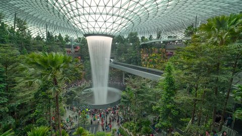 SINGAPORE APR 2019: time lapse clip of Tourists enjoying rain vortex attraction in Changi Jewel airport, Singapore