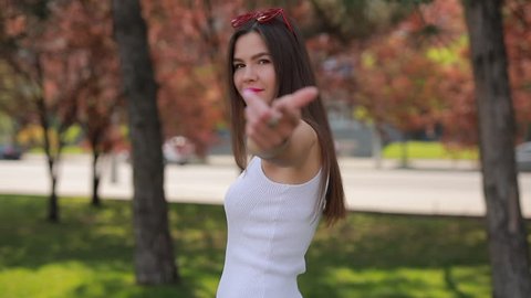 Attractive woman gestures follow me in park