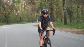 Girl cycling. Woman on bicycle. Female riding bicycle in the park. Cycling training. Front follow shot. Fitness on bicycle.