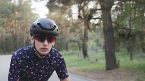Girl cycling. Woman on bicycle. Sportive focused professional cyclist woman riding a bike out of the saddle. Follow shot. Road cycling concept. Slow motion