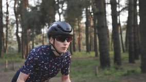 Girl cycling. Woman on bicycle. Young cute female cyclist sprinting on bicycle out of the saddle. Focused face. Cycling training. Slow motion