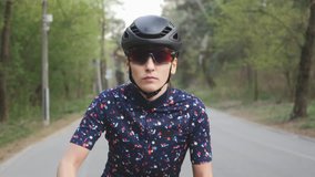 Girl cycling. Woman on bicycle. Attractive causcasian girl starts riding bicycle. Focused woman on bicycle. Girl wearing helmet and glasses on a bike. Slow motion