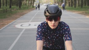 Cycling Woman on bicycle. Cycling training. Female cyclist rides bicycle in the park. Front follow shot. Cycling concept. Slow motion