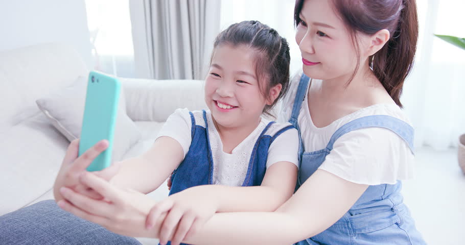 Mom and daughter take selfie together happily