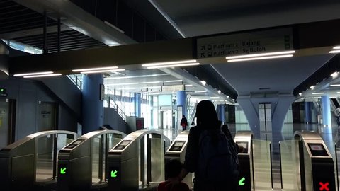 Kuala Lumpur, Malaysia 2 March 2019 : Muslim mother traveling with kid tapping ticket at MRT ticketing system in Kajang MRT station.