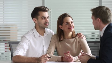 Happy young family couple sign mortgage loan investment contract sale purchase agreement handshake broker or bank manager, smiling customers and agent shake hands make business insurance leasing deal