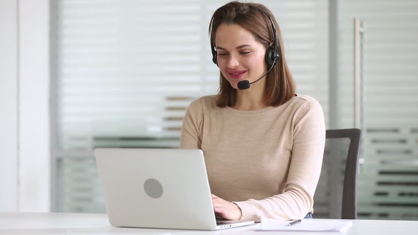 Smiling business woman customer support agent receptionist wear headset consult online client looking at laptop talk in internet computer chat, helpline operator secretary make conference video call Royalty-Free Stock Footage #1028495390