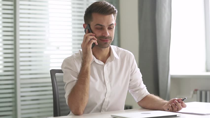 Young businessman talking on phone consulting client support customer sit at work desk, male manager entrepreneur speak by mobile smartphone having conversation on cell making business call in office Royalty-Free Stock Footage #1028495432