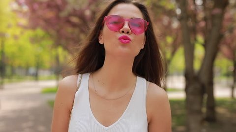 Pretty brunette woman with pink lips blowing kiss