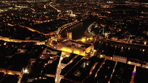 Aerial drone night video from iconic illuminated fortified medieval castle and bridge of Verona, Veneto, Italy
