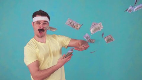 funny man with a mustache throws money and looks at the camera