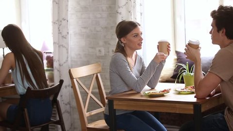 Moving camera slider shows multi-ethnic young couples sitting in cafe drinks coffee during speed dating activity, having lively pleasant conversation, romantic relationships and love seekers concept