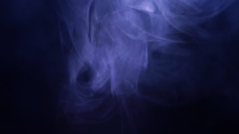 Smoke in slow motion on black background. Color smoke slowly floating through space against black background.
