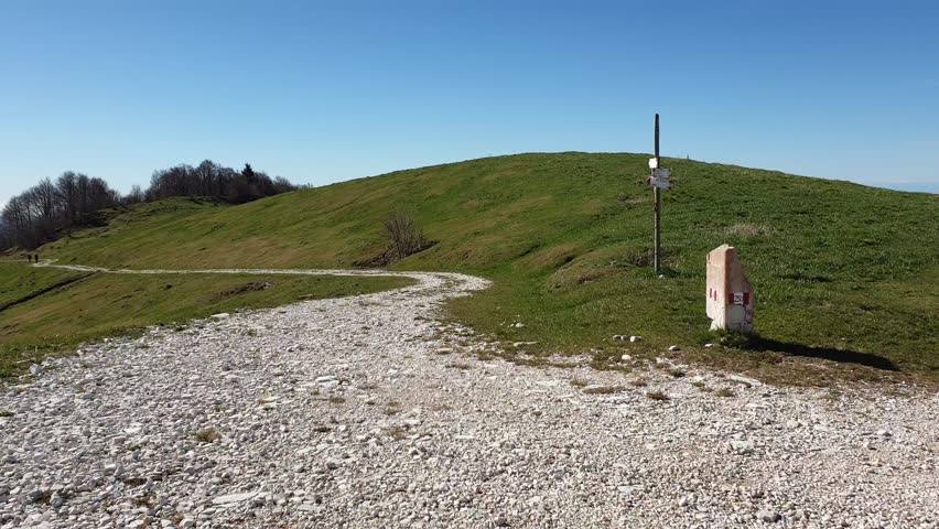 European path E5 with stone cippus and panorama of the mountains in the background