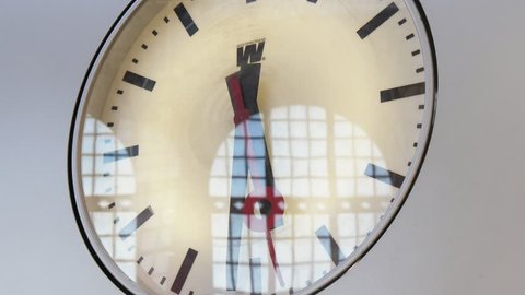  Impressive vintage looking mechanical clock with a white background two black hands and one red second hand in Antwerp train station,