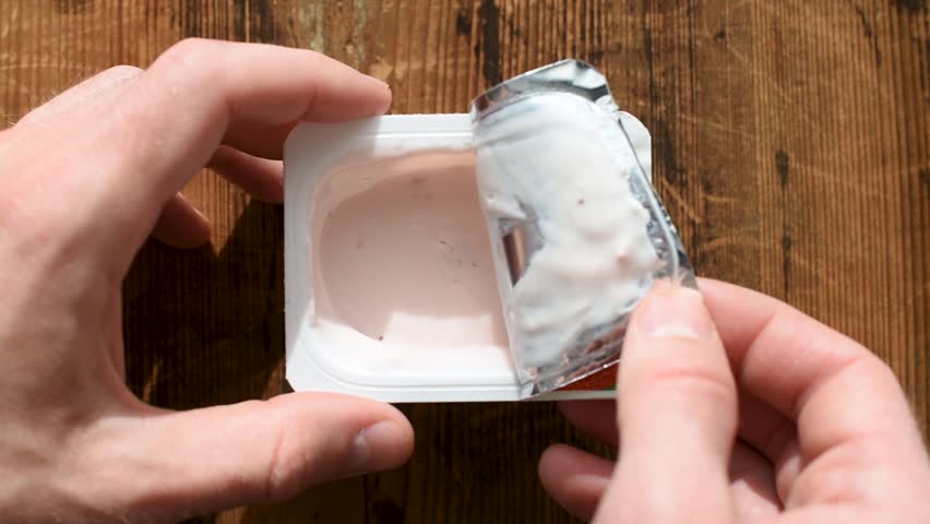 Opening jar of yogurt. Man opens plastic jar of fruit yogurt | Shutterstock HD Video #1028539259