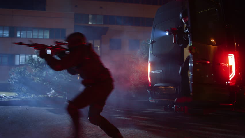 Masked Team of Armed SWAT Police Officers Exit a Black Van Parked Outside of an Office Building. Soldiers with Rifles and Flashlights Run on a Street Filled with Smoke.
