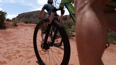 Sedona, AZ / USA - June 4, 2017: Mountain Biking over Red Rocks in Sedona, Arizona Desert Landscape