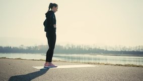 Young woman doing sports workout. 4K slow motion video. Woman running walking in outdoors park on sunny day, close-up legs sport shoes. Female exercising in the gym 