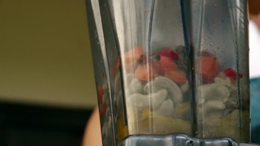 Mixing Orange and Yellow Ingredients in Blender. Side View. Preparing Vegetable Sauce. Vegan and Vegeterian Food. Lifestyle of Health and Sustainability Concept