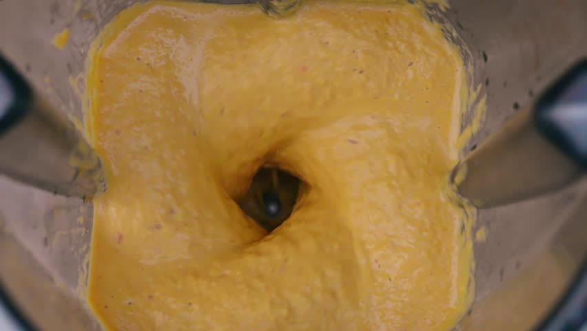 Mixing Orange and Yellow Ingredients in Blender. Top View. Preparing Vegetable Sauce. Vegan and Vegeterian Food. Lifestyle of Health and Sustainability Concept