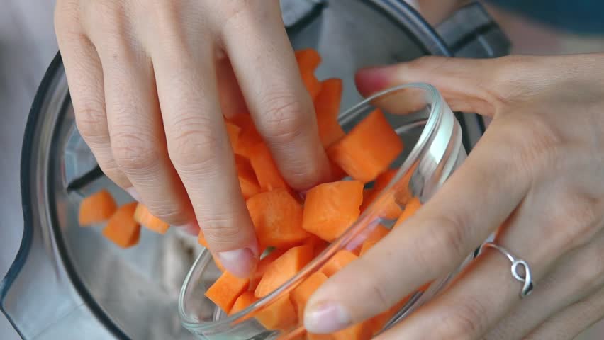 Female Hands Add Carrot into Blender to Cook Vegetable Sauce. Top View, Vegan and Vegeterian Food. Lifestyle of Health and Sustainability Concept