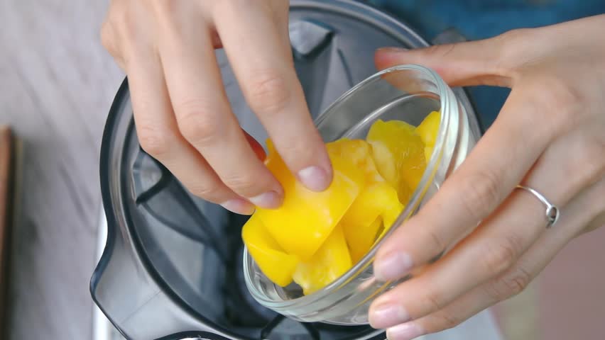 Female Hands Add Yellow Bell Pepper into Blender to Cook Vegetable Sauce. Top View, Vegan and Vegeterian Food. Lifestyle of Health and Sustainability Concept