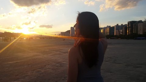 carefree woman happy on the beach enjoying sunset on Santos Brazil 
