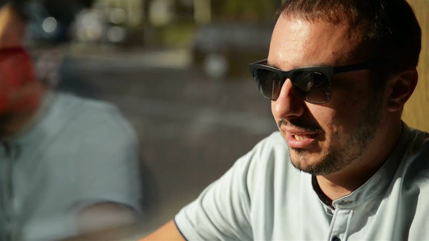 Close Up Portrait Of Handsome Bearded Man. He Is Sitting In Coffee Cafe With His Girlfriend.
