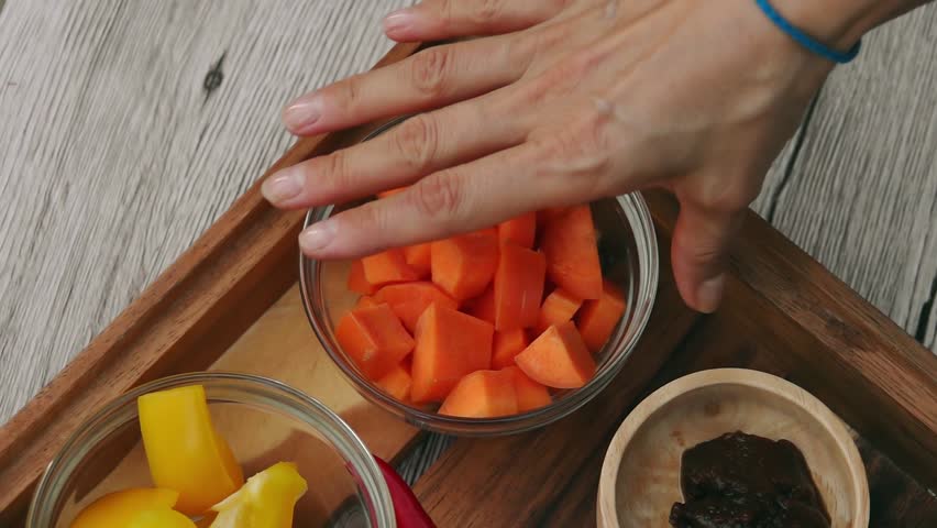 Female Hands Taking Cut Carrot Cubes from Tray. Vegan and Vegeterian Food. Lifestyle of Health and Sustainability Concept