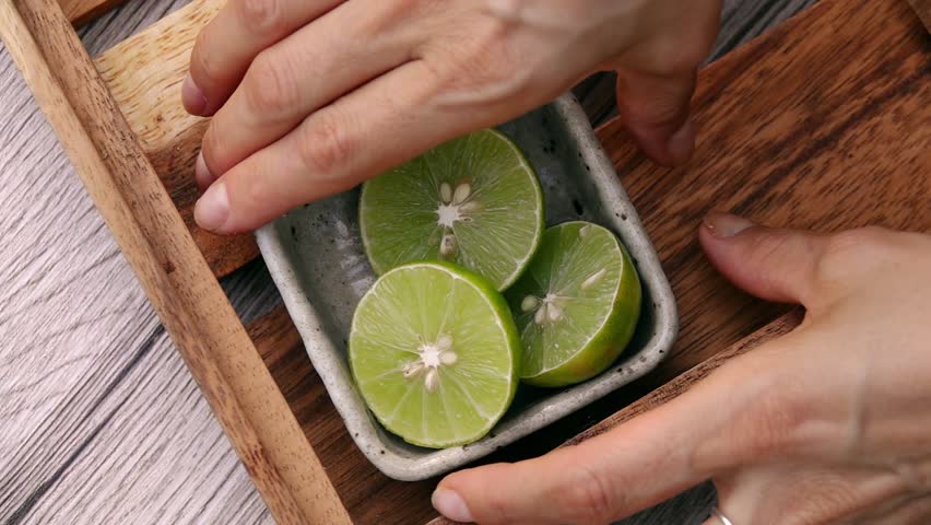 Female Hands Taking Lime Halves from Tray. Top View. Vegan and Vegeterian Food. Lifestyle of Health and Sustainability Concept
