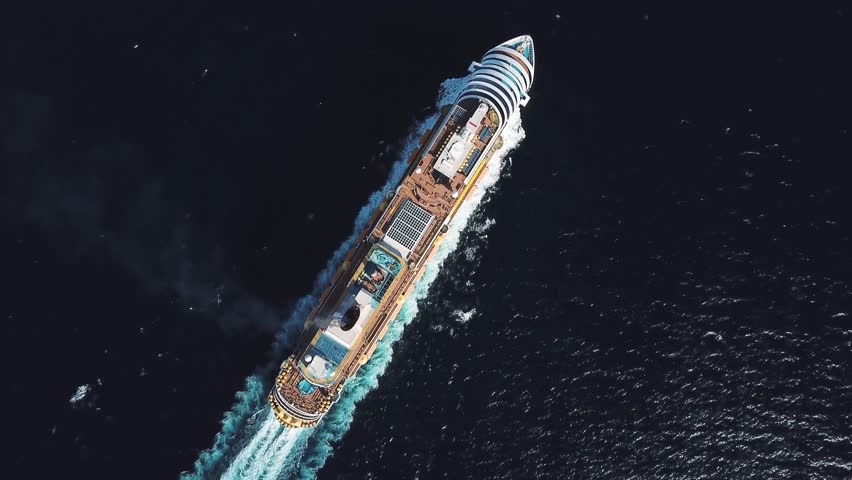 Aerial top view of luxury large cruise ship sailing full speed on open water, luxury vacation concept. Stock. Large Cruise ship sailing across The Mediterranean sea.