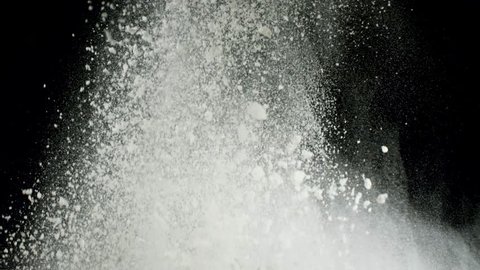 Splash of white powder isolated on black background. Stock footage. Close up for white abstract snow being thrown up.