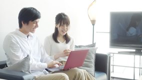 Young asian couple watching a laptop together.